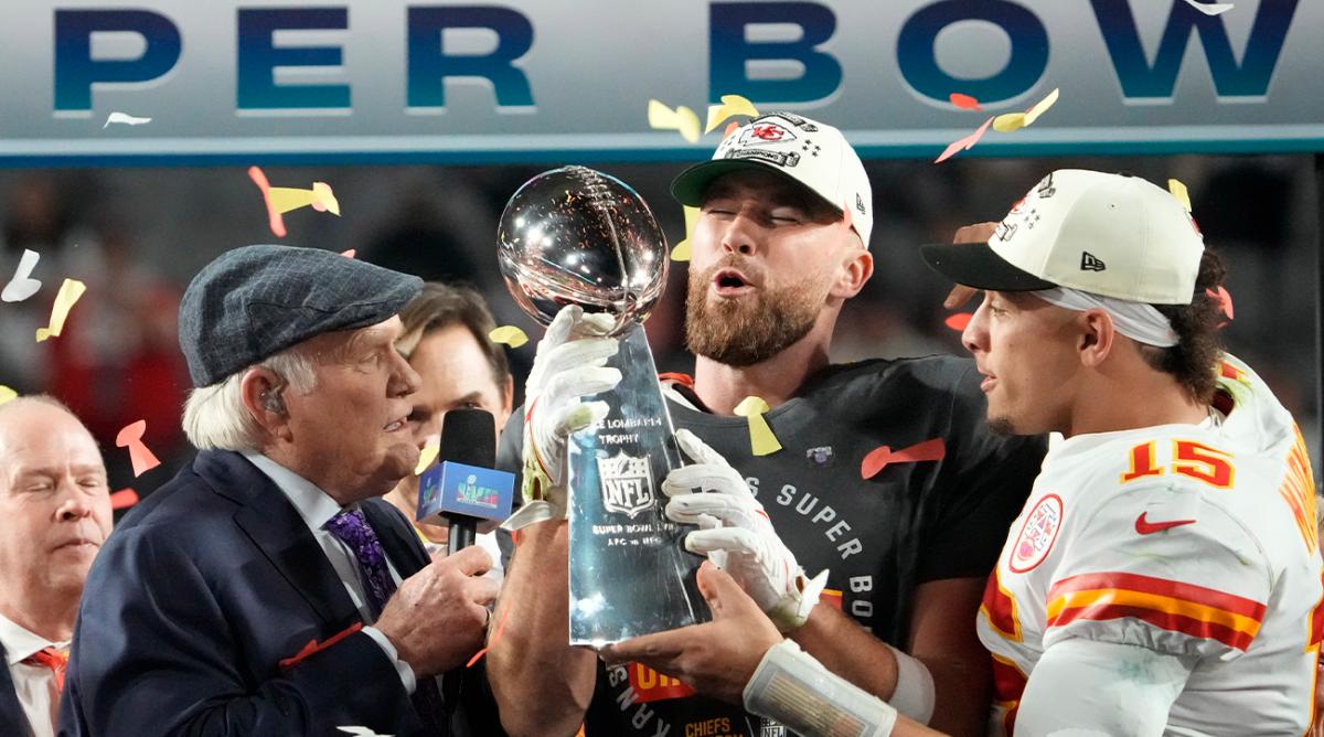 Feb 12, 2023; Glendale, AZ, USA; Kansas City Chiefs quarterback Patrick Mahomes (15) passes the the Lombardi Trophy to tight end Travis Kelce (87) after defeating the Philadelphia Eagles in Super Bowl LVII at State Farm Stadium.