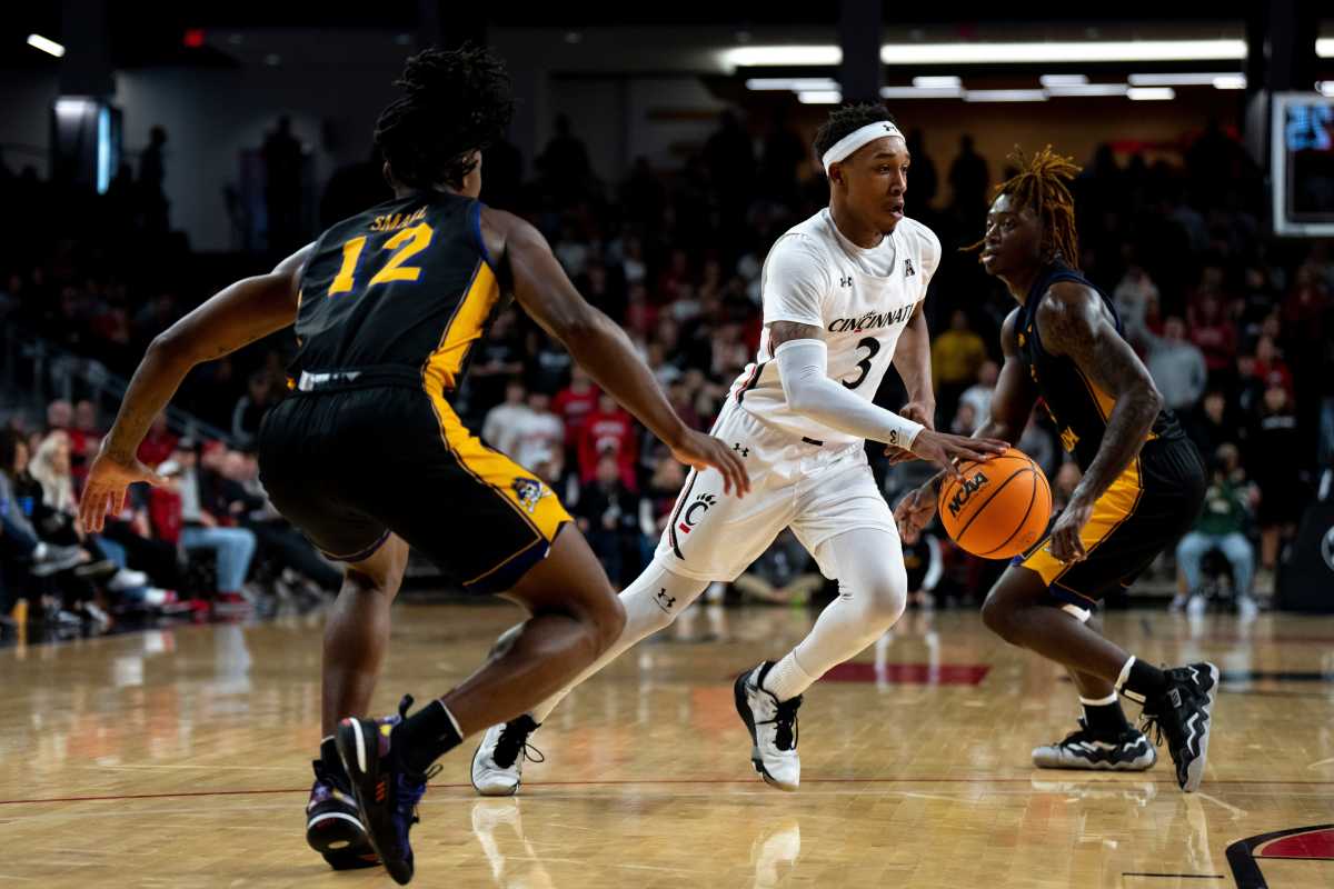 Cincinnati Bearcats guard Mika Adams-Woods (3) dribbles as East Carolina Pirates guard Javon Small (12) guards him in the first half of the NCAA men s basketball game at Fifth Third Arena in Cincinnati on Wednesday, Jan. 11, 2023. Ncaa Basketball Eastern Carolina Pirates At Cincinnati Bearcats