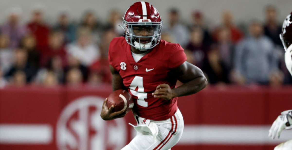 Alabama Crimson Tide quarterback Jalen Milroe on a rushing attempt during a college football game in the SEC.