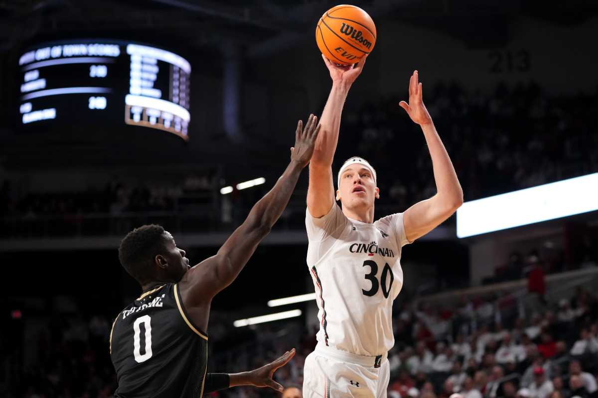 Cincinnati Bearcats forward Viktor Lakhin (30) rises for a shot as UCF Knights forward Lahat Thioune (0) defends in the first half of a college basketball game between the UCF Knights and the Cincinnati Bearcats, Saturday, Feb. 4, 2023, at Fifth Third Arena in Cincinnati. Ucf Knights At Cincinnati Bearcats Feb 4 0012