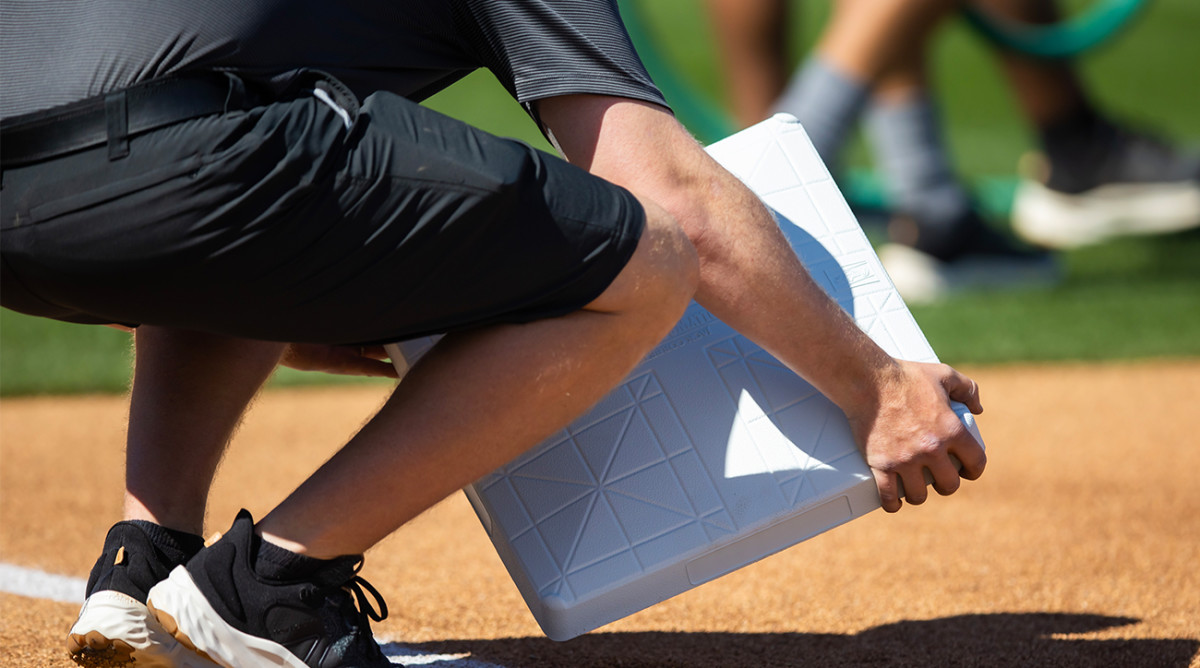 Groundskeeper lays down a new, larger MLB base.