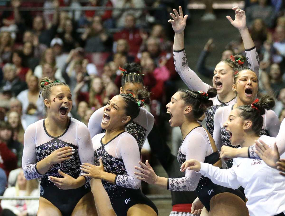 Alabama gymnast Lilly Hudson, left, reacts with teammates after scoring her first 10.0 on the beam at Coleman Coliseum during the meet against LSU.