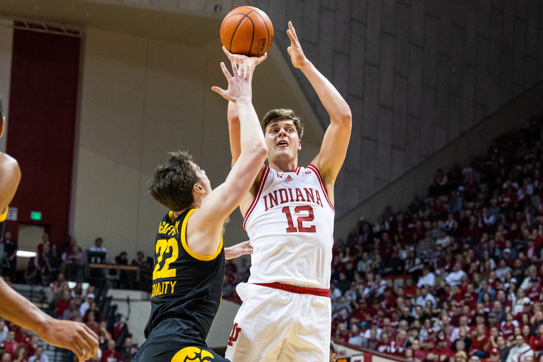 Indiana Hoosiers forward Miller Kopp (12) shoots the ball while Iowa Hawkeyes forward Patrick McCaffery (22) defends in the first half at Simon Skjodt Assembly Hall.