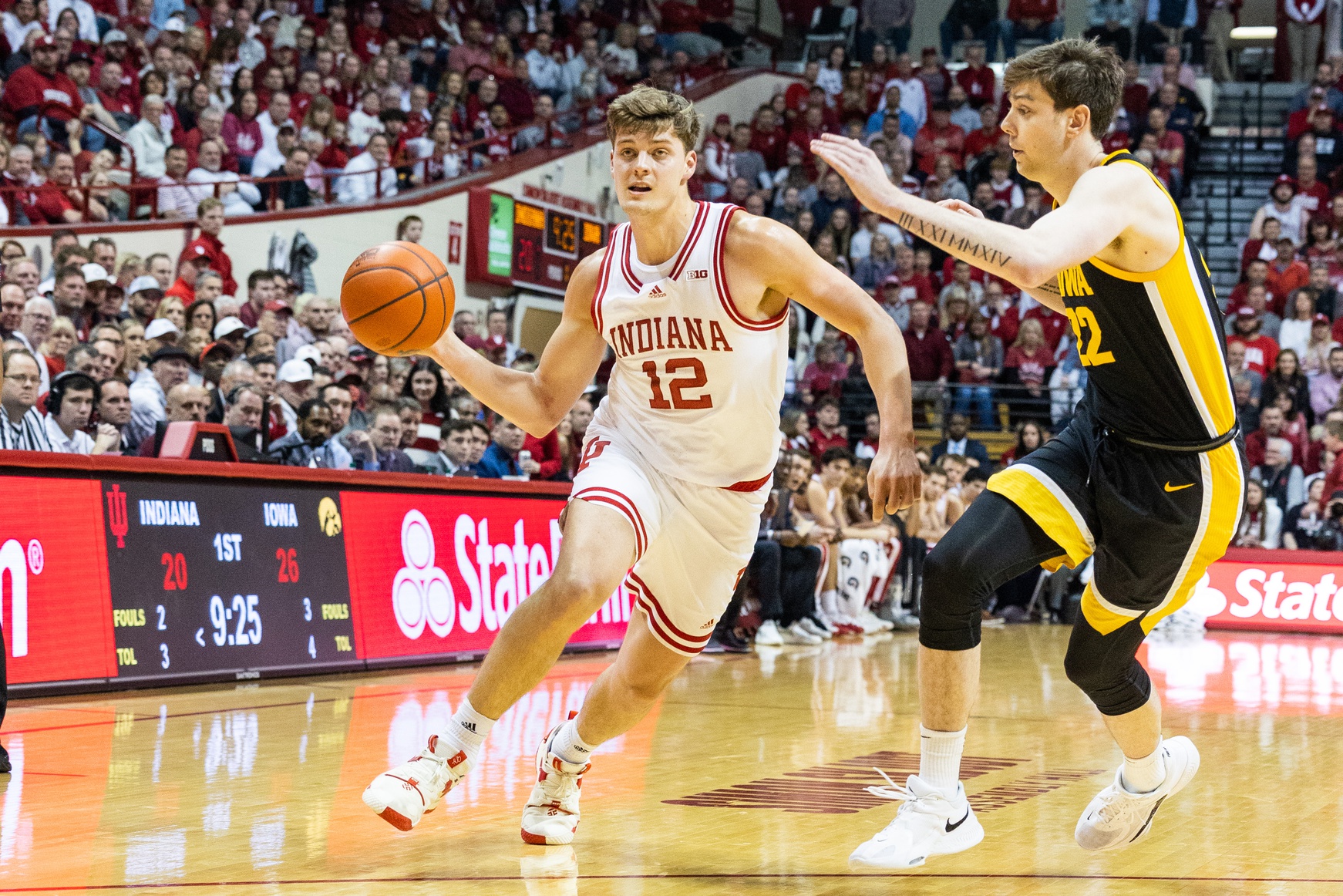 Indiana Hoosiers forward Miller Kopp (12) passes the ball while Iowa Hawkeyes forward Patrick McCaffery (22) defends in the first half at Simon Skjodt Assembly Hall.
