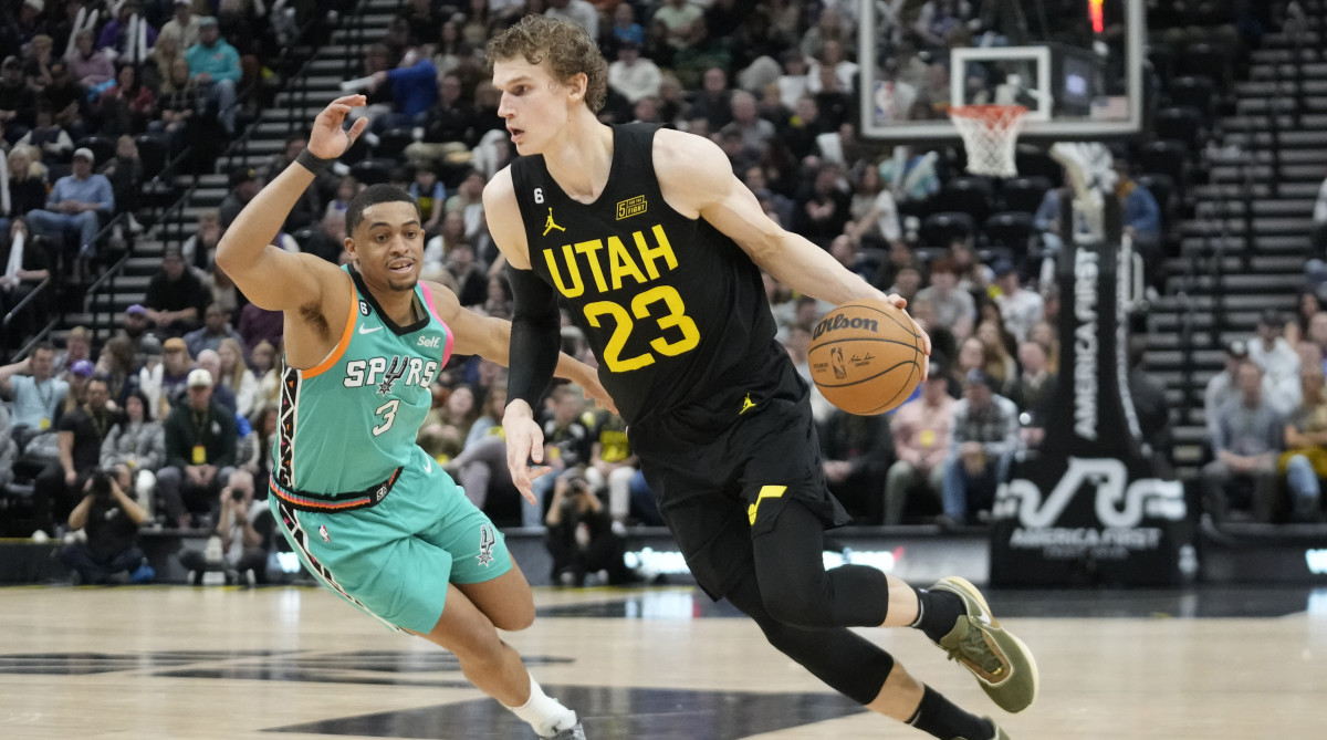 Jazz forward Lauri Markkanen tries to dribble past Spurs forward Keldon Johnson.