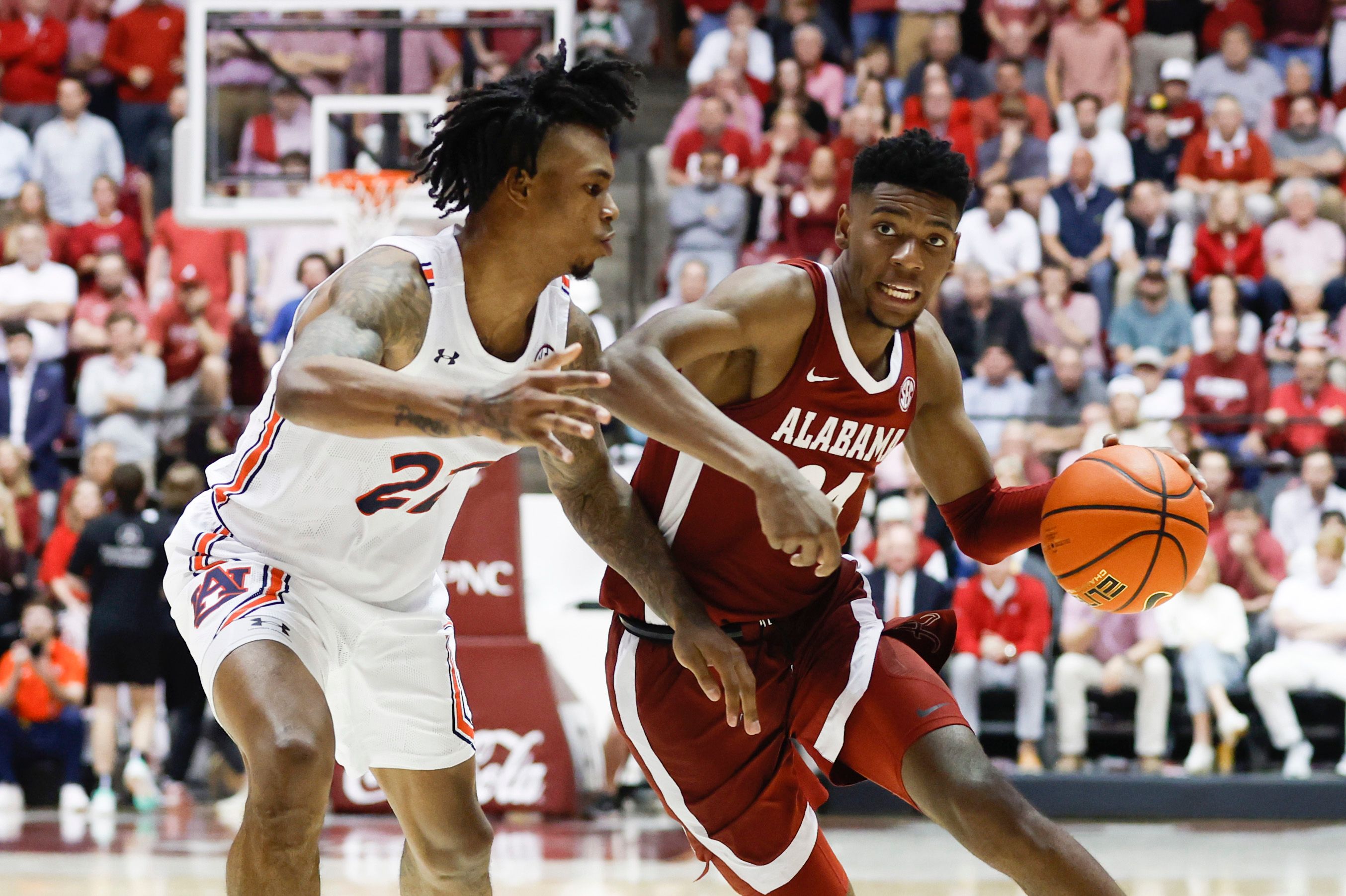 Alabama Crimson Tide forward Brandon Miller (24) dribbles around Auburn Tigers guard Allen Flanigan (22) during the second half of an NCAA basketball game at Coleman Coliseum.
