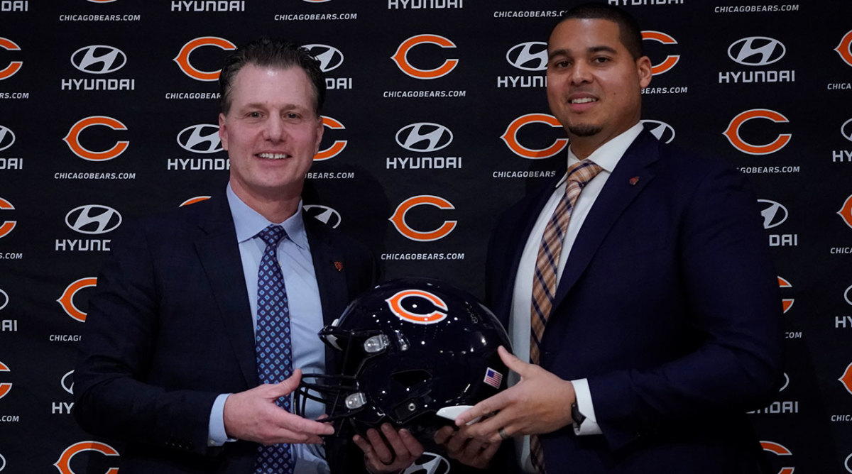 Matt Eberflus and Ryan Poles pose at a press conference with a Bears helmet.