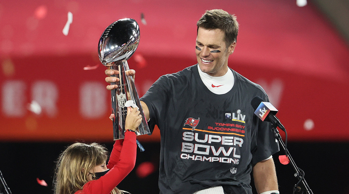Buccaneers quarterback Tom Brady (12) hoists the Vince Lombardi Trophy with his daughter, Vivian, after defeating the Chiefs in Super Bowl LV at Raymond James Stadium.