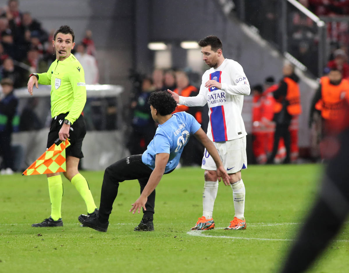 A pitch invader pictured falling to the floor in front of a surprised Lionel Messi after PSG's 2-0 defeat at Bayern Munich