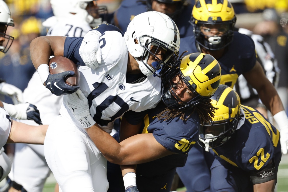 Oct 15, 2022; Ann Arbor, Michigan, USA; Penn State Nittany Lions running back Nicholas Singleton (10) is tackled by Michigan Wolverines linebacker Mike Morris (90) in the first half at Michigan Stadium. Mandatory Credit: Rick Osentoski-USA TODAY Sports