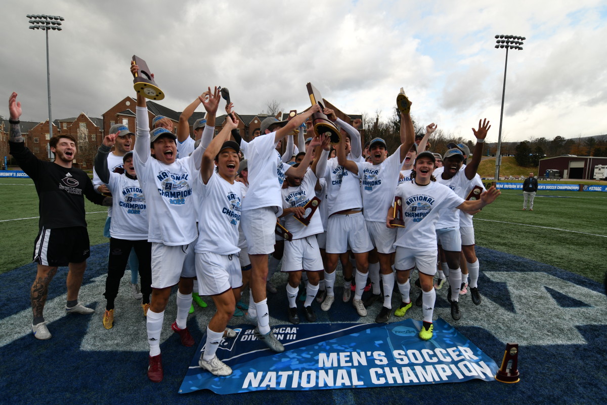 the Uchicago Men’s soccer team celebrates holding the trophy up after winning the national title