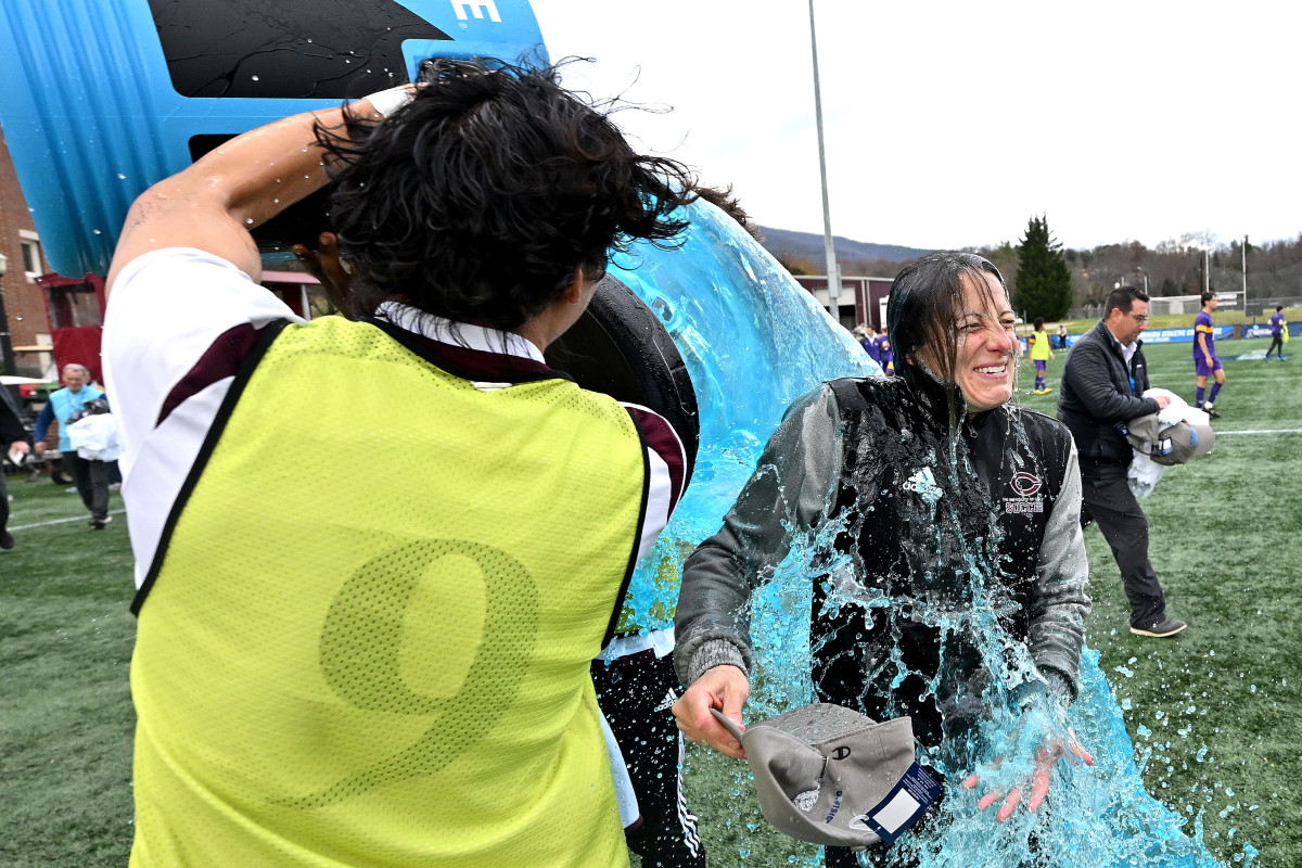 A player in a yellow pinnie dumps blue Powerade over coach Julianne Sitch
