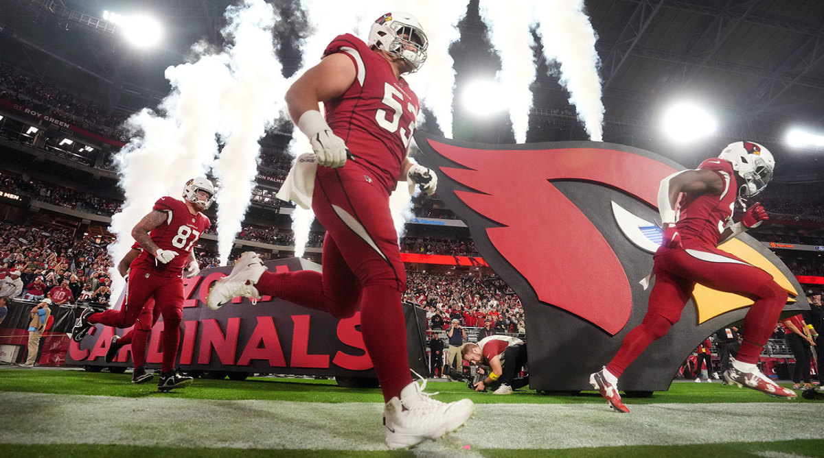 Arizona Cardinals players run onto the field