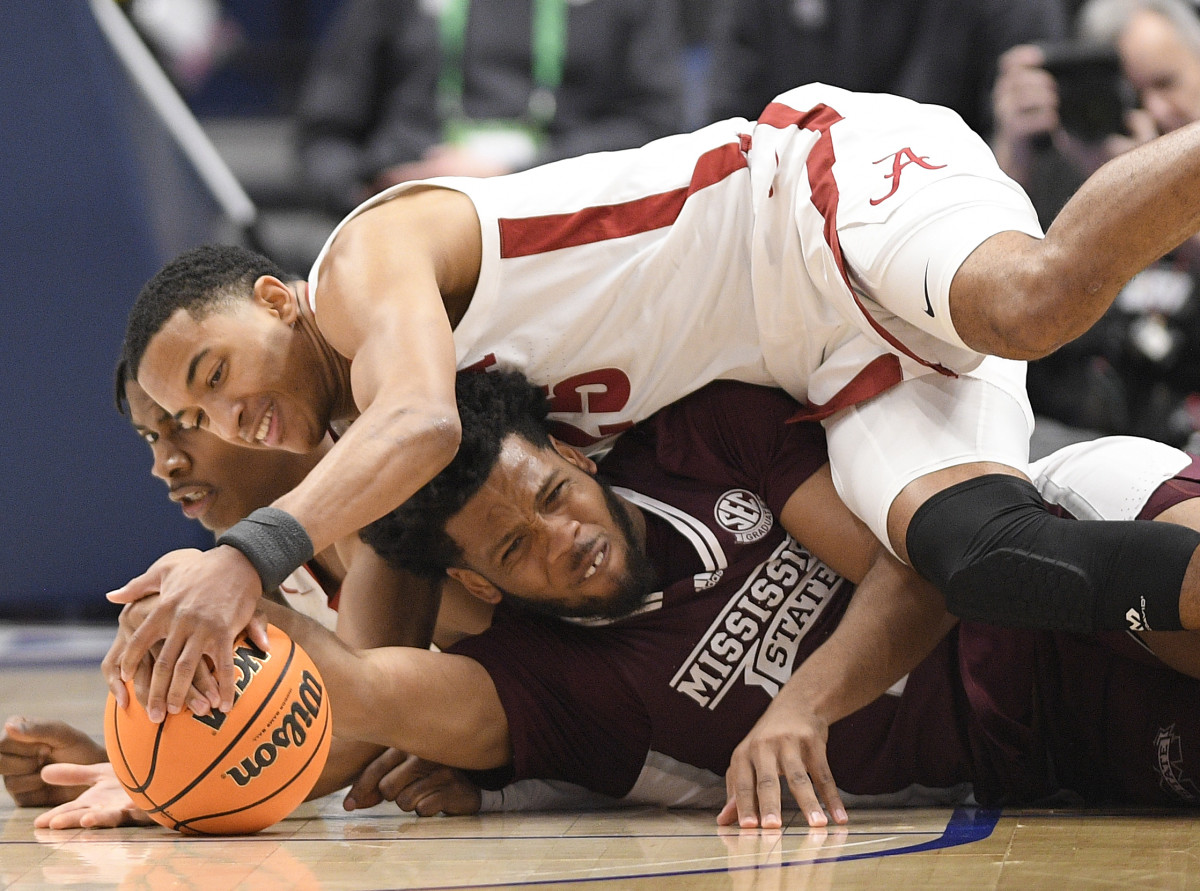 Alabama Crimson Tide guard Dominick Welch (10) and Alabama Crimson Tide Nimari Burnett (25) fight with Mississippi State Bulldogs forward Will McNair Jr. (13) for the loose ball during the second half at Bridgestone Arena.