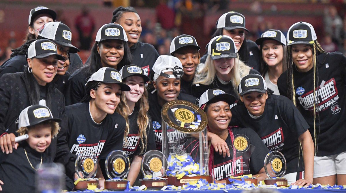 South Carolina players gather around the SEC championship trophy after the SEC Women’s Basketball Tournament.