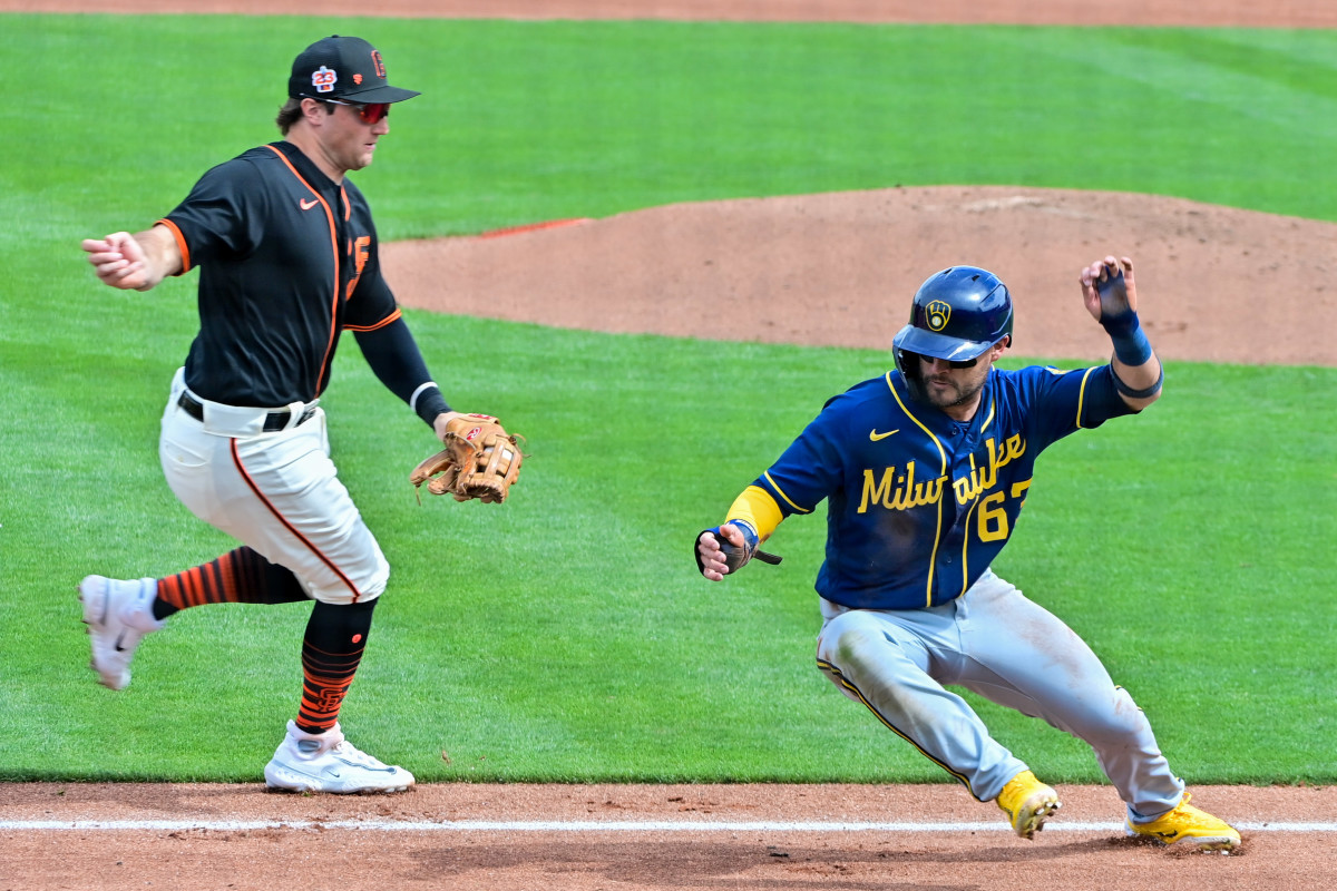 Brewers shortstop Eddy Alvarez dodges a tag by SF Giants third baseman Casey Schmitt in the third inning during a Spring Training game at Scottsdale Stadium. (2023)