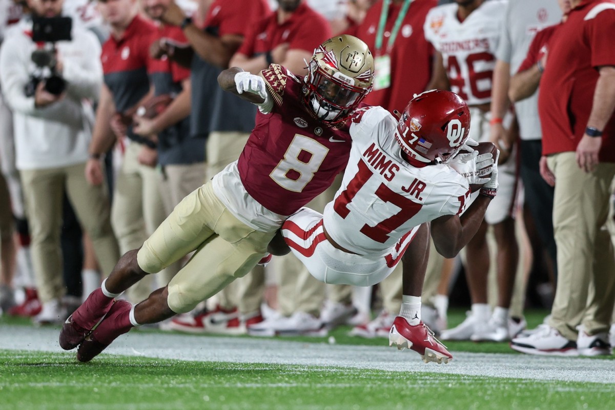 Dec 29, 2022; Orlando, Florida, USA; Oklahoma Sooners wide receiver Marvin Mims Jr. (17) catches a pass while defended by Florida State Seminoles defensive back Renardo Green (8) in the fourth quarter during the 2022 Cheez-It Bowl at Camping World Stadium. Mandatory Credit: Nathan Ray Seebeck-USA TODAY Sports
