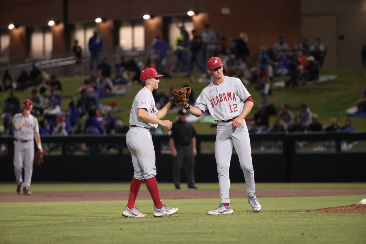 Alabama's Colby Shelton and Hunter Furtado touch gloves in the Crimson Tide's 3-0 loss to the No. 5 Florida Gators on March. 16, 2023 at Condron Family Ballpark in Gainesville, Fla.