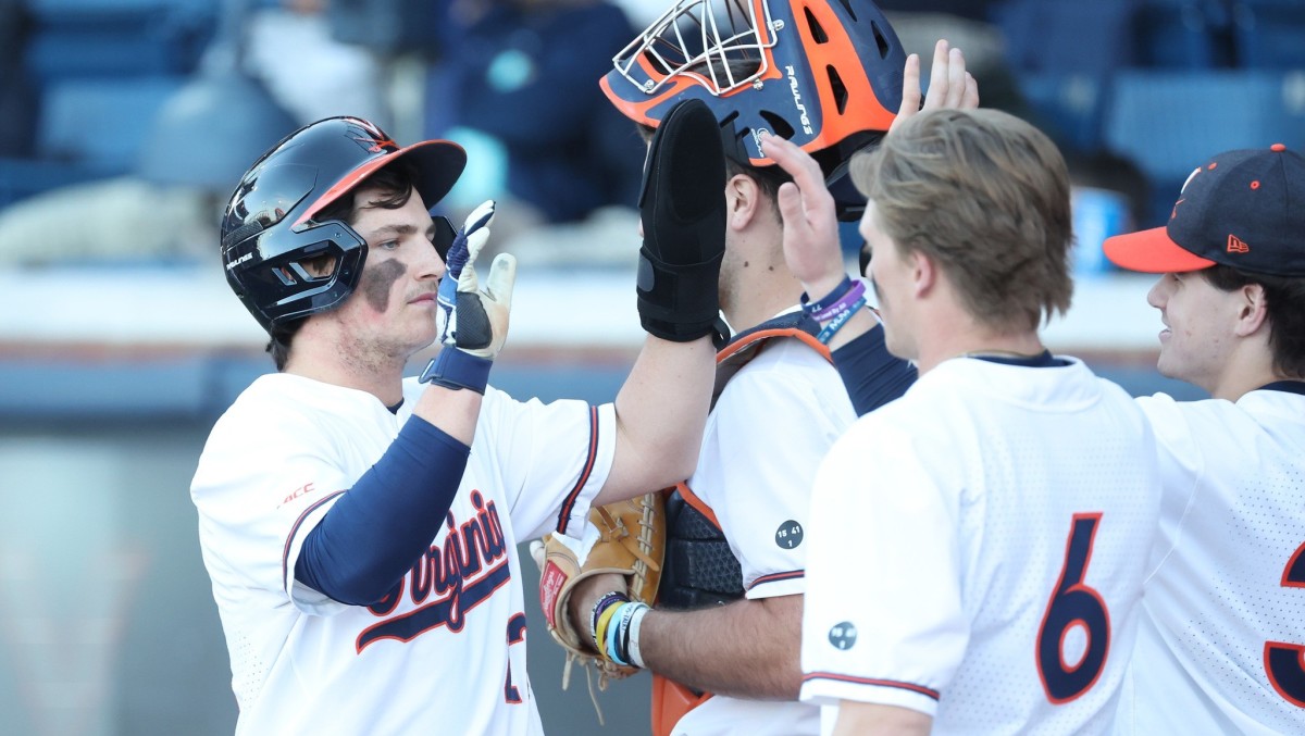 Jake Gelof celebrates with his teammates after scoring a run during the Virginia baseball game against Longwood.