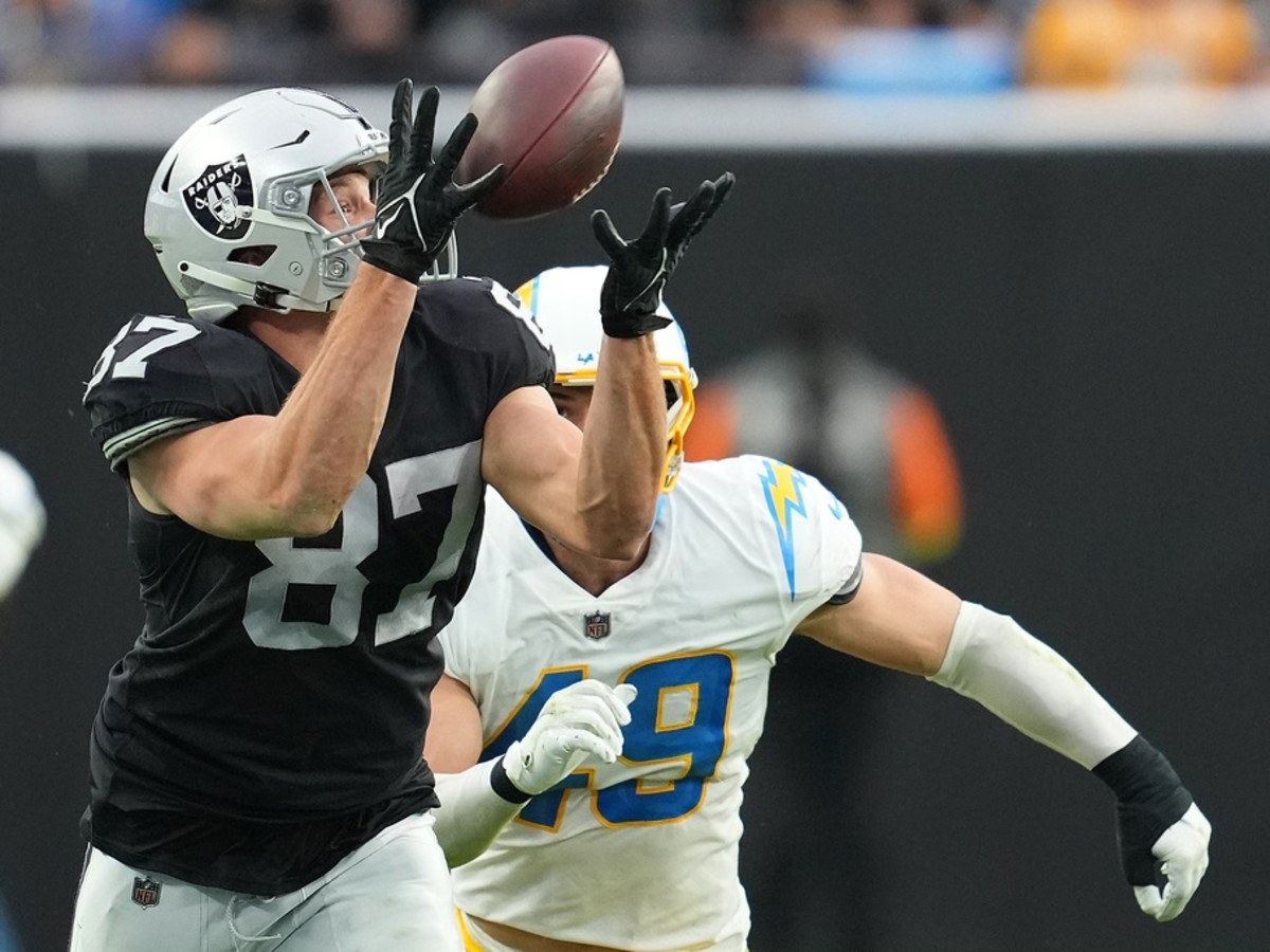 Las Vegas Raiders tight end Foster Moreau (87) makes a catch over Los Angeles Chargers linebacker Drue Tranquill (49). Mandatory Credit: Stephen R. Sylvanie-USA TODAY Sports