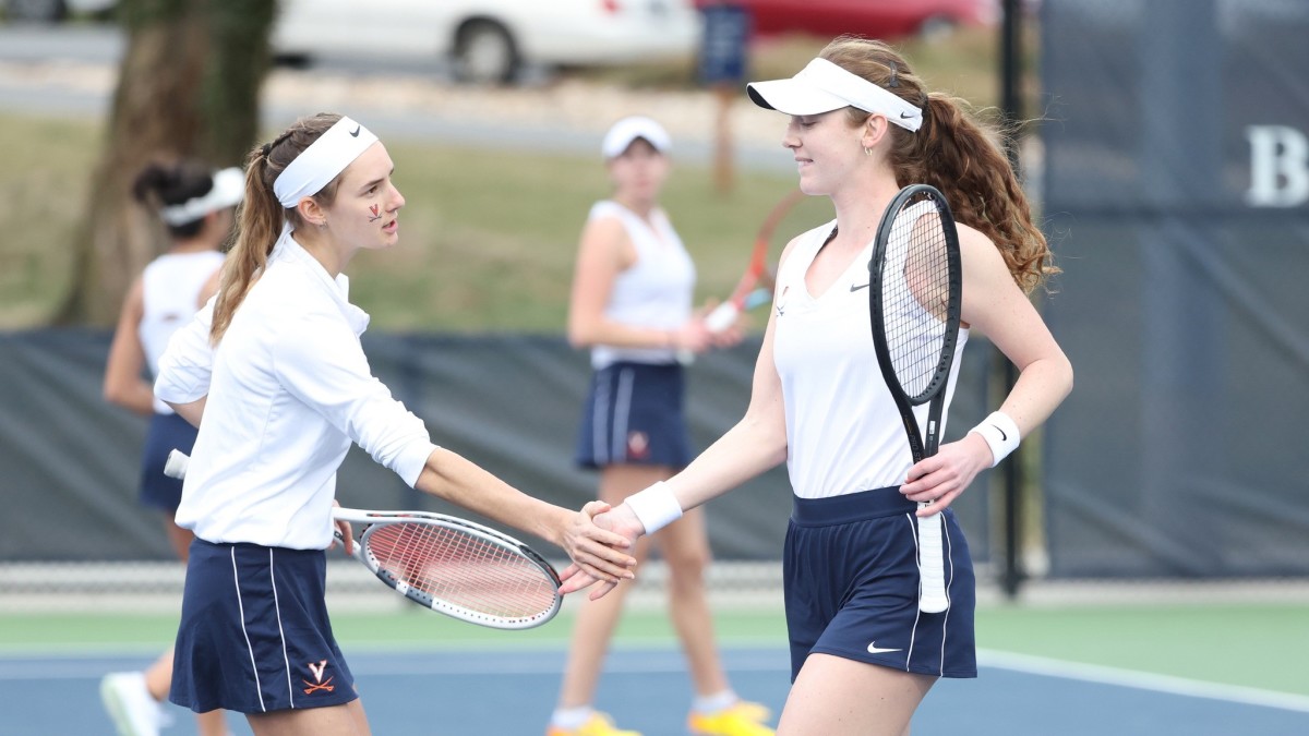 Melodie Collard and Julia Adams celebrate after scoring a point in doubles play during the Virginia women's tennis match against North Carolina at Boar's Head Sports Club.
