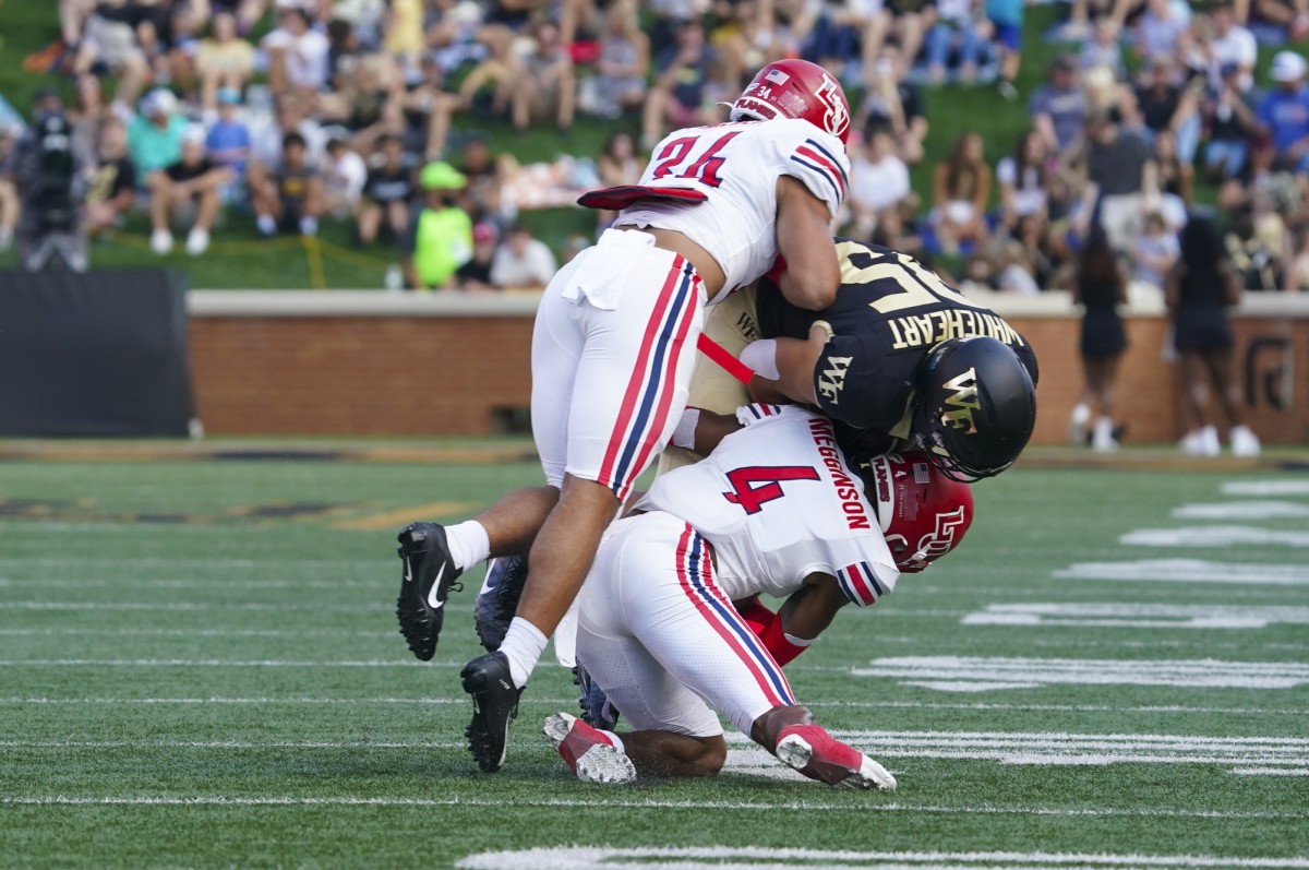 Sep 17, 2022; Winston-Salem, North Carolina, USA; Wake Forest Demon Deacons tight end Blake Whiteheart (85) is stopped after his catch by Liberty Flames cornerback Chris Megginson (4) and linebacker Ahmad Walker (34) during the first half at Truist Field. Mandatory Credit: James Guillory-USA TODAY Sports