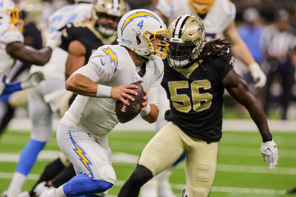 Aug 26, 2022; Los Angeles Chargers quarterback Chase Daniel (4) scrambles from a pressuring New Orleans Saints linebacker Demario Davis (56). Mandatory Credit: Stephen Lew-USA TODAY