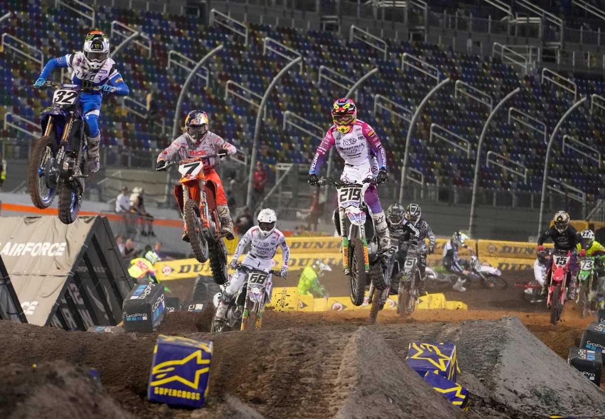 supercross racers jump over a series of dirt bumps