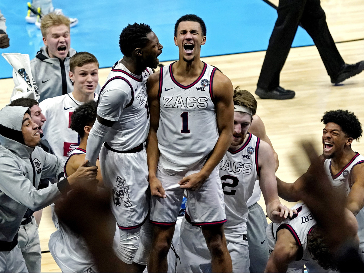 Gonzaga’s Jalen Suggs stands on the scorer’s table with his teammates surrounding him to celebrate his game-winning shot against UCLA in the 2021 NCAA tournament.