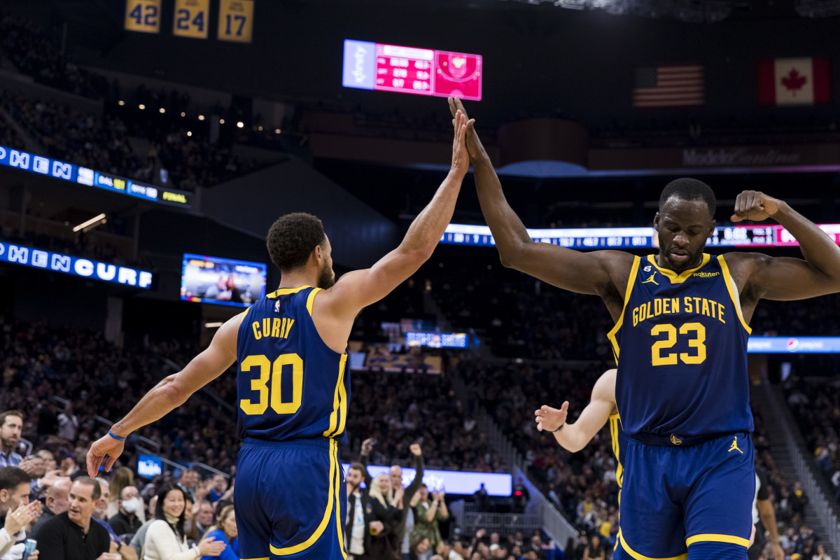 Golden State Warriors guard Stephen Curry and forward Draymond Green high five on the court