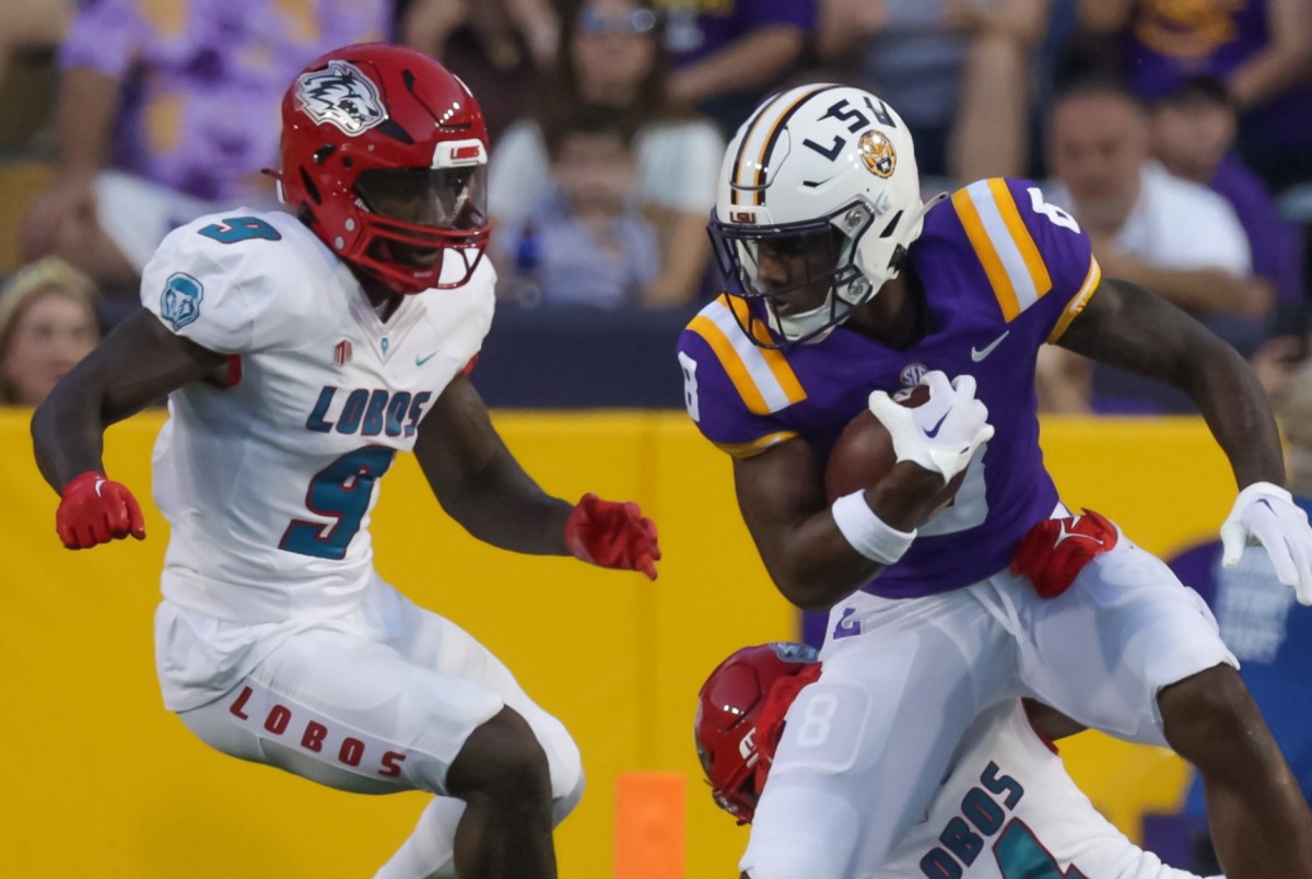 LSU Tigers wide receiver Malik Nabers (8) catchers a pass against New Mexico Lobos cornerback A.J. Odums (4) and safety Jerrick Reed II (9) during the first half at Tiger Stadium.