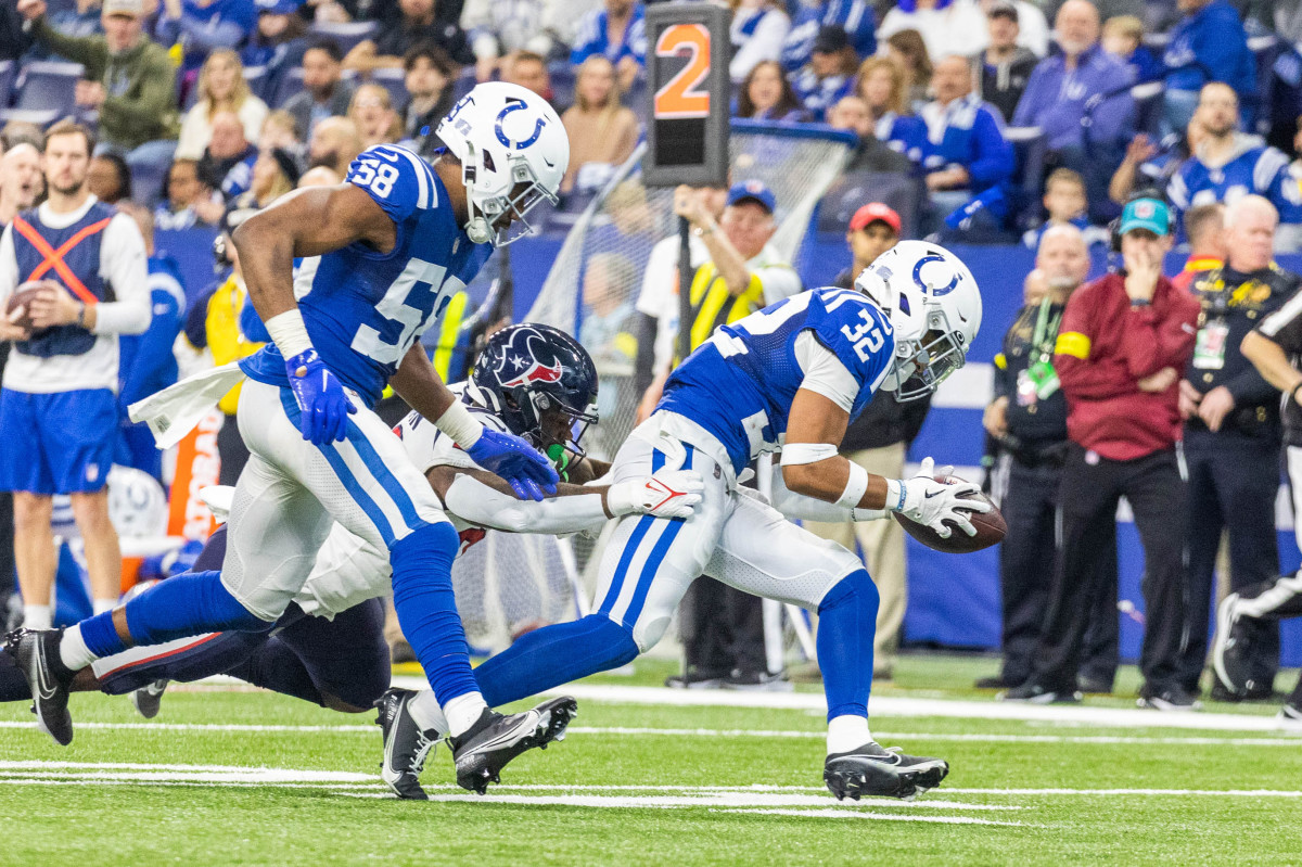 Jan 8, 2023; Indianapolis, Indiana, USA; Indianapolis Colts safety Julian Blackmon (32) recovers a fumble by Houston Texans running back Royce Freeman (26) in the first half at Lucas Oil Stadium. Mandatory Credit: Trevor Ruszkowski-USA TODAY Sports