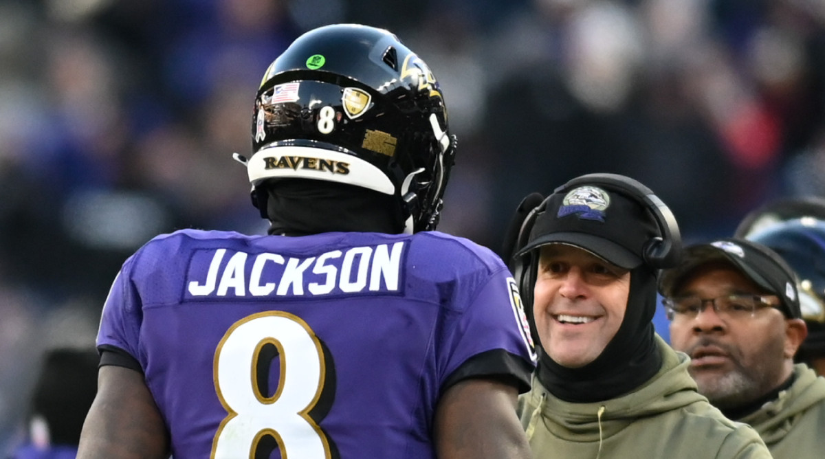 Ravens quarterback Lamar Jackson approaches coach John Harbaugh on the sidelines during a game in 2022.