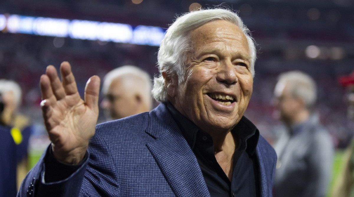 Patriots owner Robert Kraft smiles and waves on the field