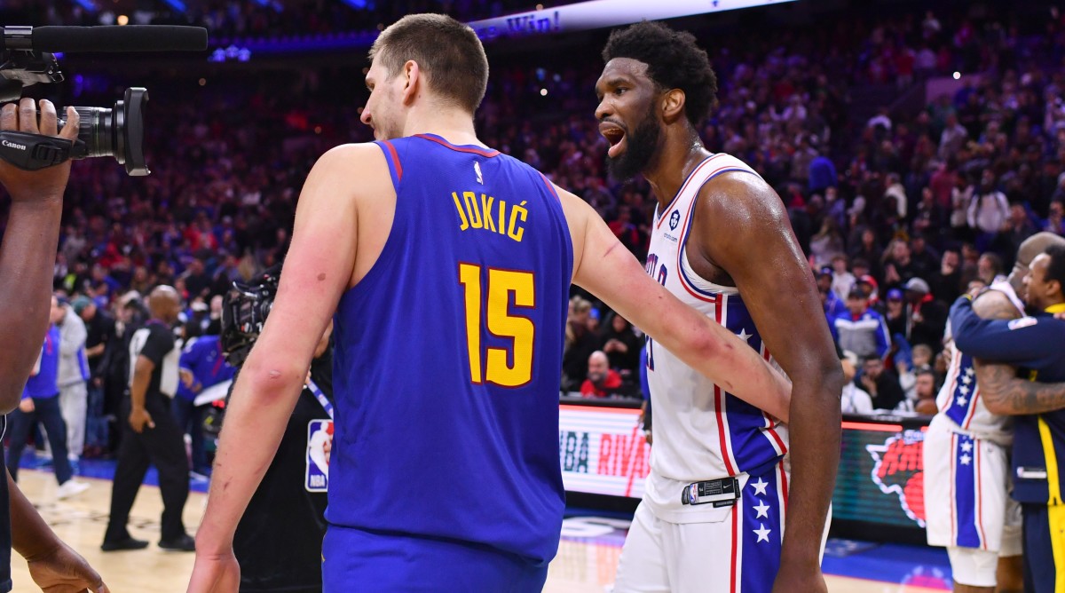 Nuggets center Nikola Jokic (15) and 76ers center Joel Embiid (21) meet after a game at Wells Fargo Center.