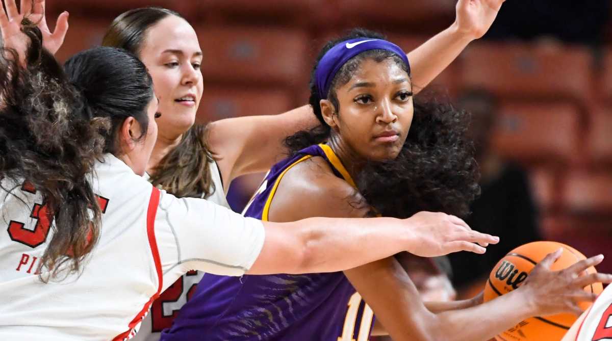 LSU forward Angel Reese keeps the ball away from defenders in the post