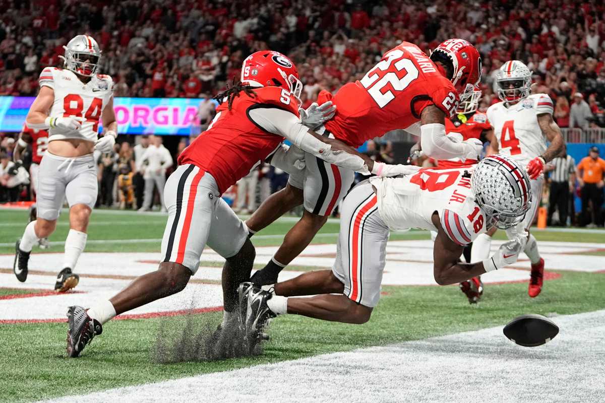 Dec 31, 2022; Atlanta, Georgia, USA; Ohio State Buckeyes wide receiver Marvin Harrison Jr. (18) takes a hit from Georgia Bulldogs defensive back Javon Bullard (22) during the second half of the Peach Bowl in the College Football Playoff semifinal at Mercedes-Benz Stadium. Ohio State lost 42-41. Mandatory Credit: Adam Cairns-The Columbus Dispatch Syndication The Columbus Dispatch