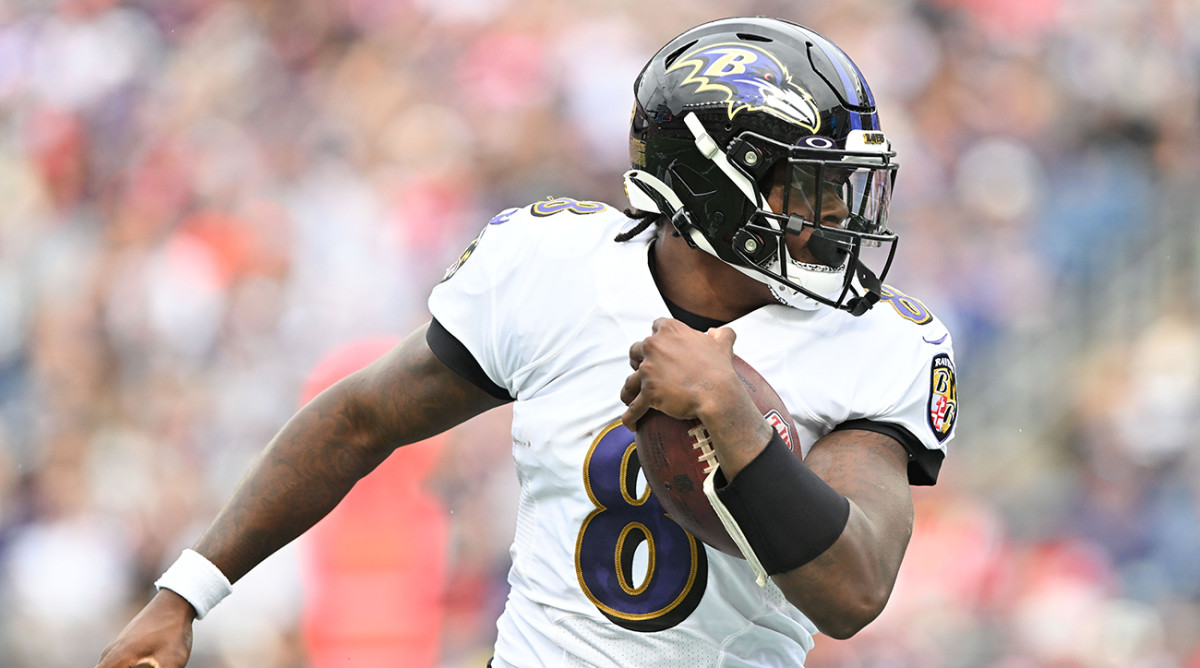 Ravens quarterback Lamar Jackson (8) runs with ball during the second half of a game against the Patriots at Gillette Stadium.