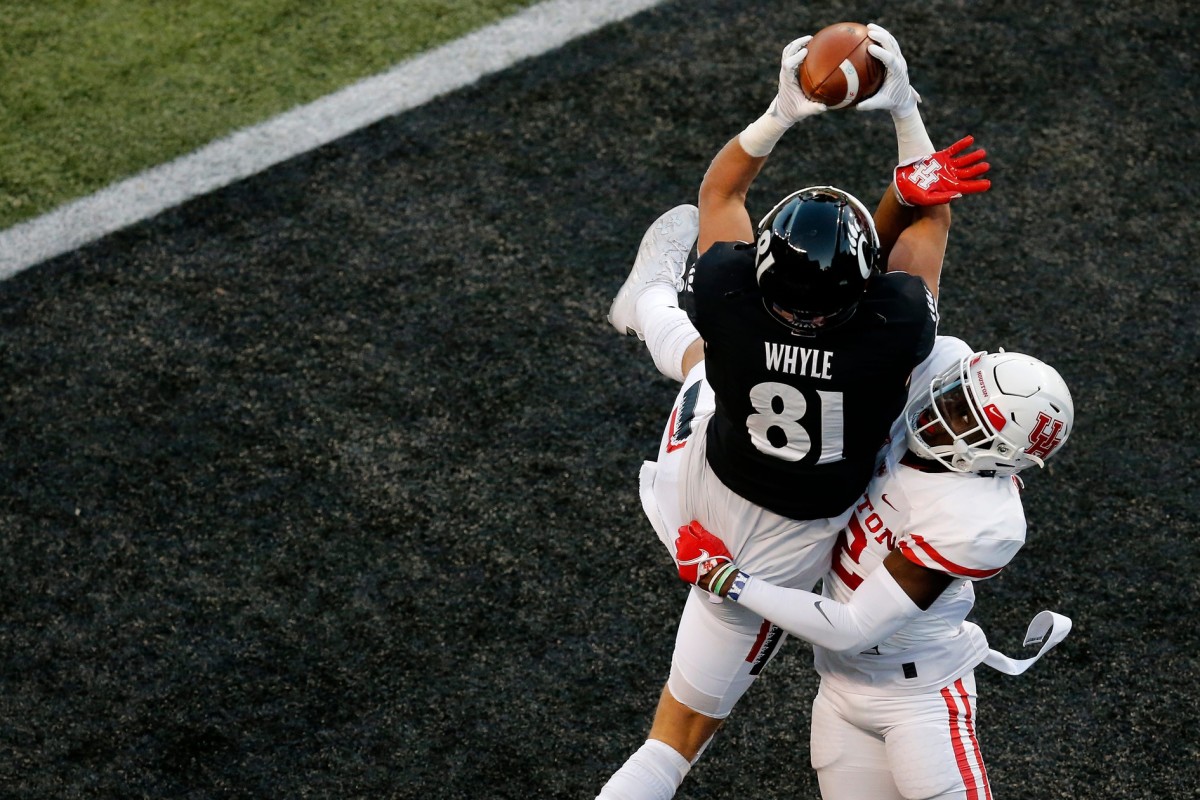 Cincinnati Bearcats tight end Josh Whyle (81) makes a leaping catch over Houston Cougars safety Gervarrius Owens (32) for a touchdown in the second quarter of the American Athletic Conference football game between the University of Houston Cougars and the University of Cincinnati Bearcats at Nippert Stadium in Cincinnati on Saturday, Nov. 7, 2020. Houston Cougars At Cincinnati Bearcats Football