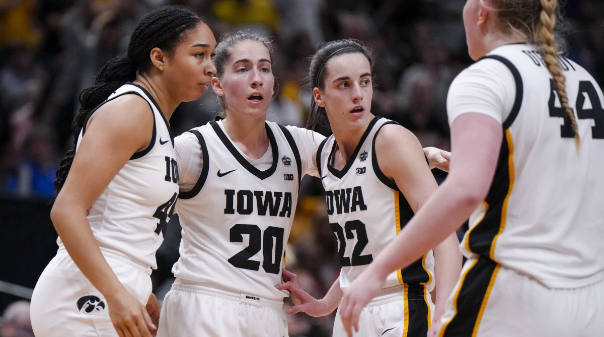 Iowa Hawkeyes forward Hannah Stuelke, left, guard Kate Martin, middle, and guard Caitlin Clark huddle