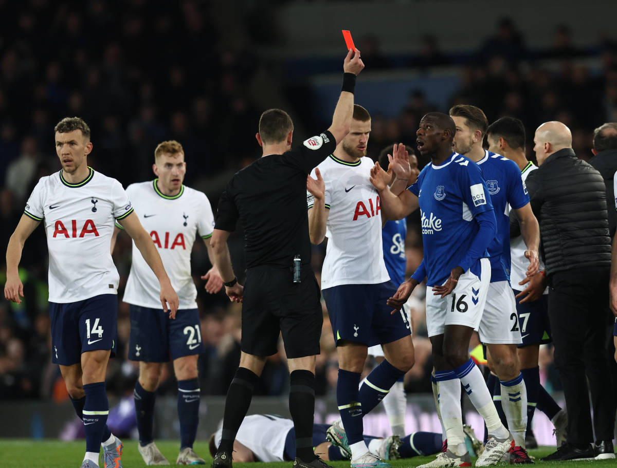 Referee David Coote pictured showing a red card to Everton midfielder Abdoulaye Doucoure (no.16) during a game against Tottenham in April 2023