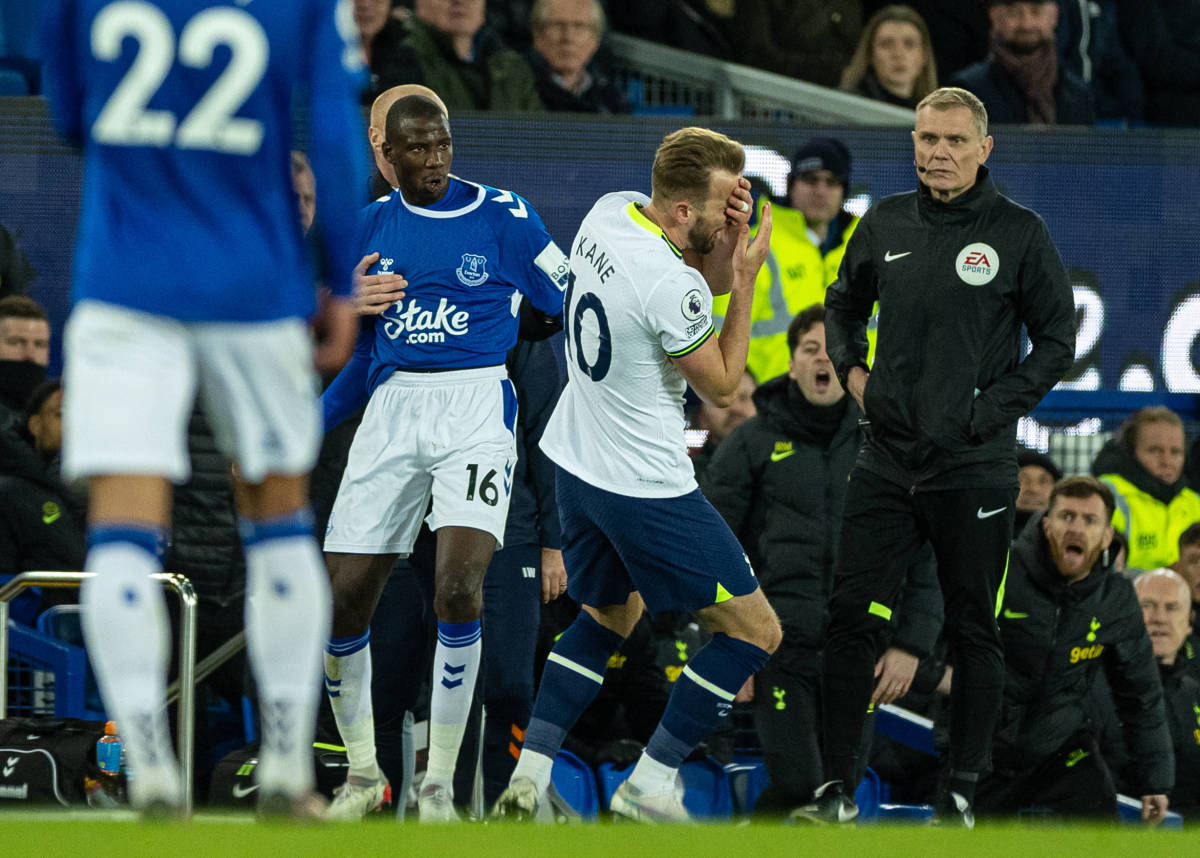 Harry Kane pictured falling to the ground while holding his face after being struck by Everton midfielder Abdoulaye Doucoure during a game in April 2023