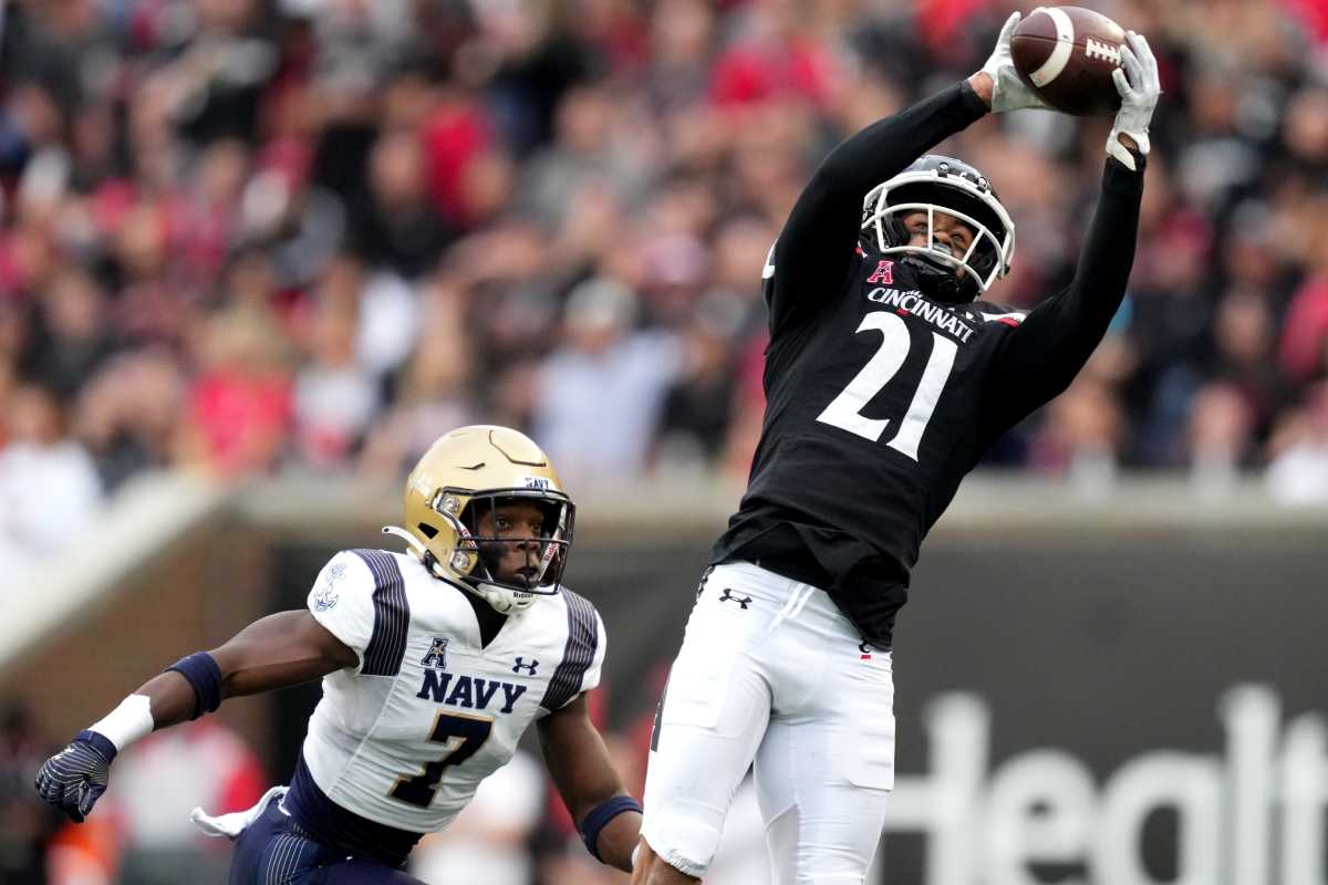 Cincinnati Bearcats wide receiver Tyler Scott (21) completes a catch as Navy Midshipmen cornerback Mbiti Williams Jr. (7) defends in the first quarter during a college football game, Saturday, Nov. 5, 2022, at Nippert Stadium in Cincinnati. Ncaaf Navy Midshipmen At Cincinnati Bearcats Nov 6 0143