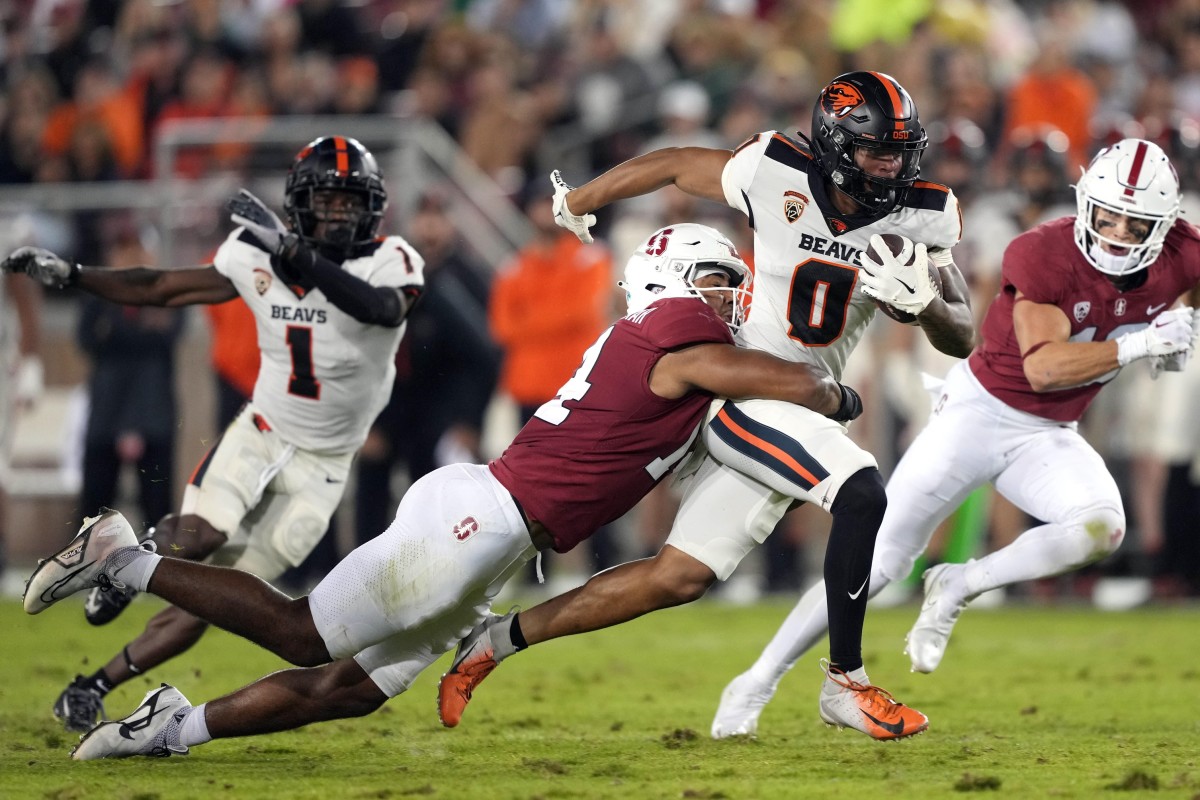 Oct 8, 2022; Stanford, California, USA; Oregon State Beavers wide receiver Tre'Shaun Harrison (0) carries the ball while being tackled by Stanford Cardinal linebacker Jacob Mangum-Farrar (14) during the second quarter at Stanford Stadium.