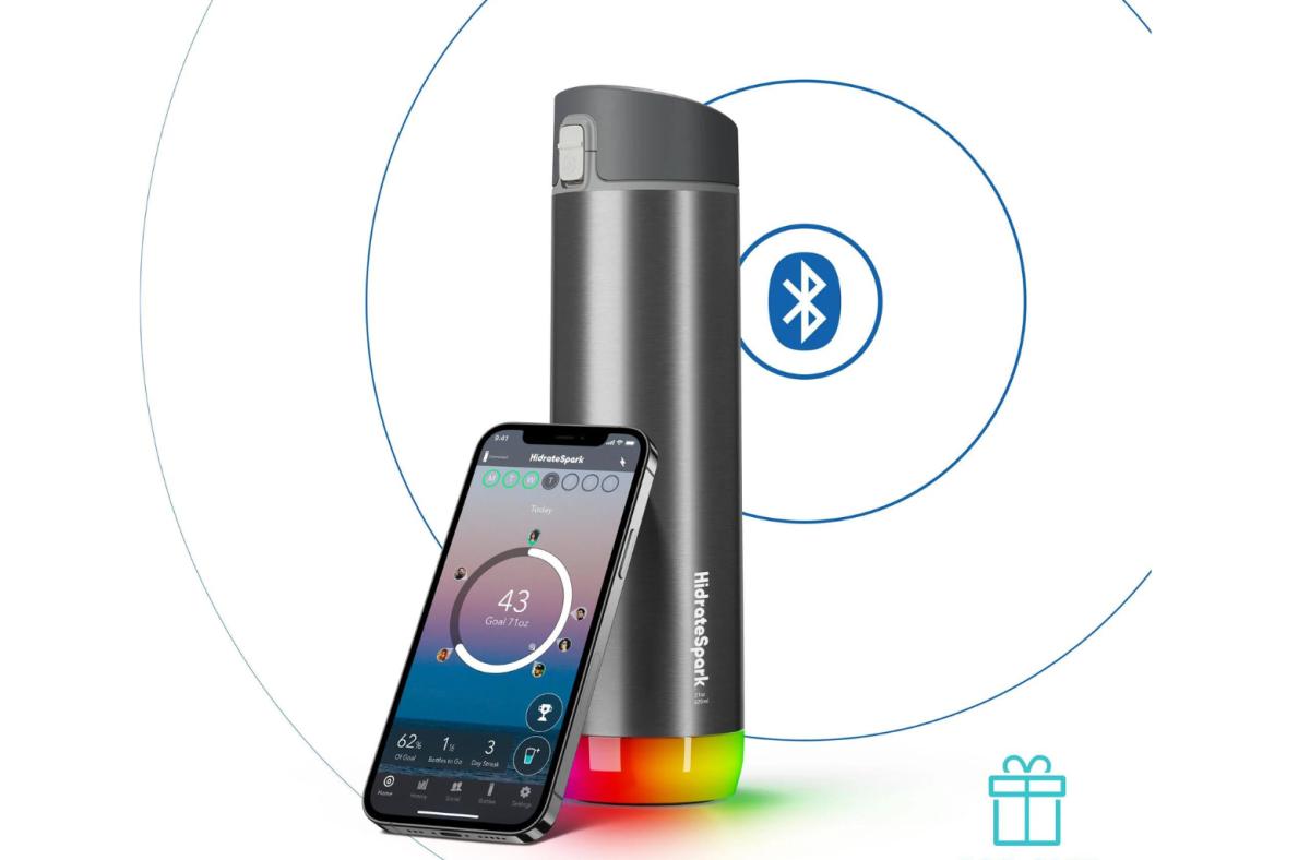 HidrateSpark Pro water bottle in steel grey next to a smartphone opened to the HidrateSpark app
