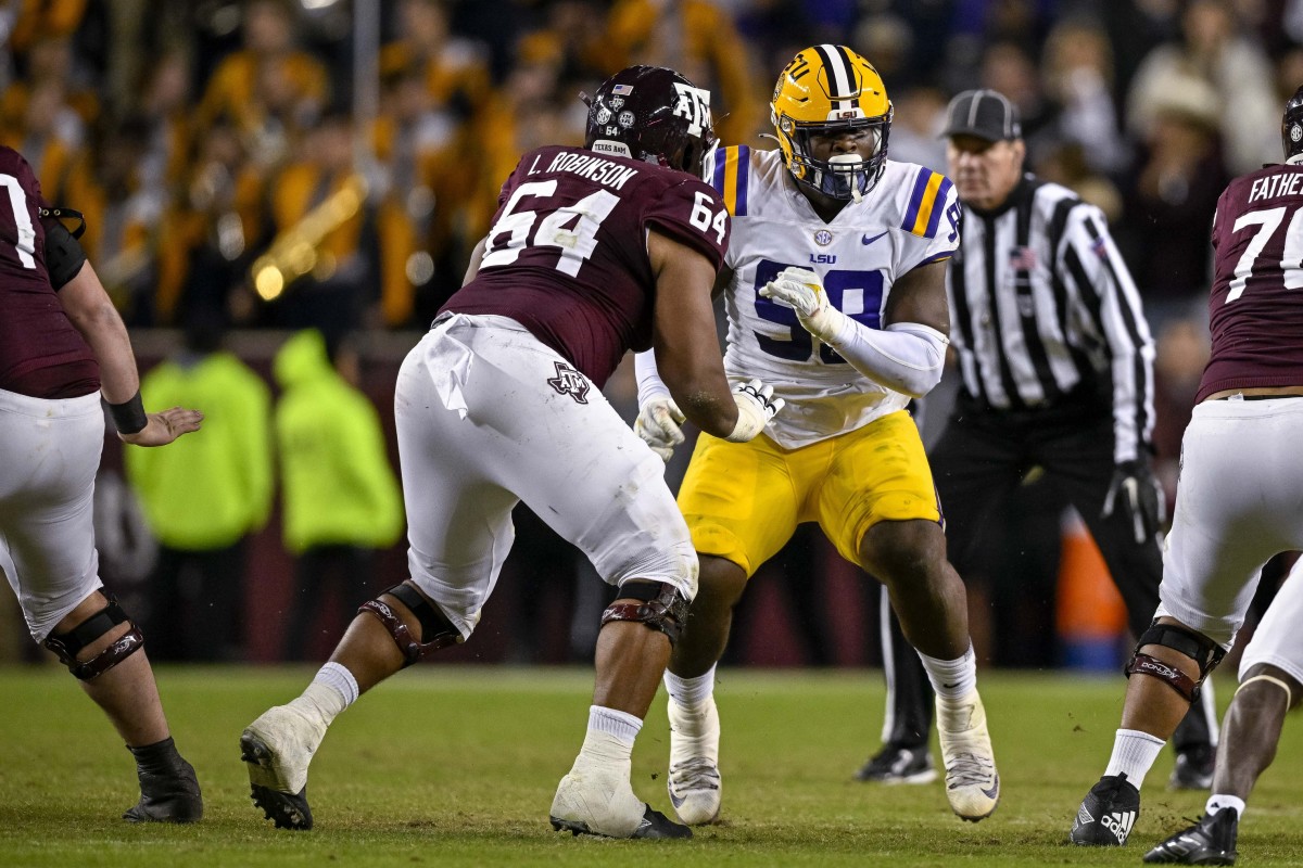 Nov 26, 2022; College Station, Texas, USA; Texas A&M Aggies offensive lineman Layden Robinson (64) and LSU Tigers defensive tackle Jaquelin Roy (99) in action during the game between the Texas A&M Aggies and the LSU Tigers at Kyle Field. Mandatory Credit: Jerome Miron-USA TODAY Sports