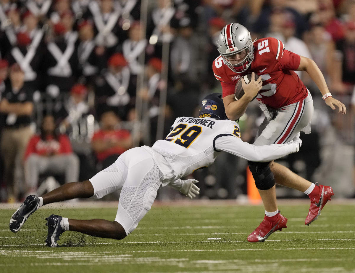Sep 17, 2022; Columbus, Ohio, USA; Ohio State Buckeyes quarterback Devin Brown (15) is tackled by Toledo Rockets cornerback Nick Turner (29) during a college football game at Ohio Stadium. Mandatory Credit: Barbara Perenic-USA TODAY Sports