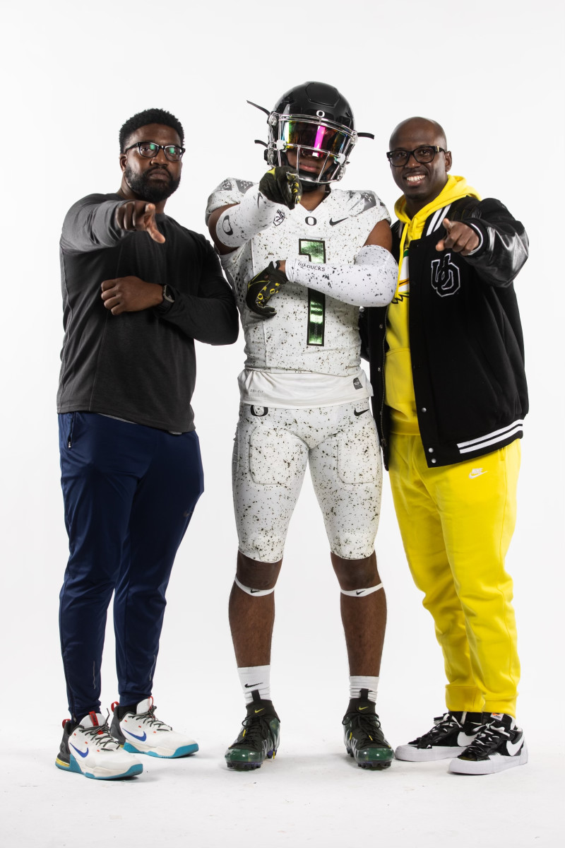 Aaron Flowers during a photoshoot with Oregon safeties coach Chris Hampton (right).
