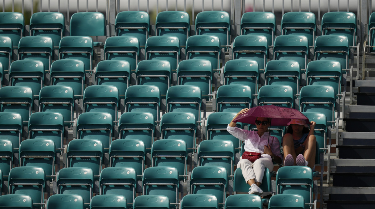 Two fans sit among empty seats at the Miami Open.