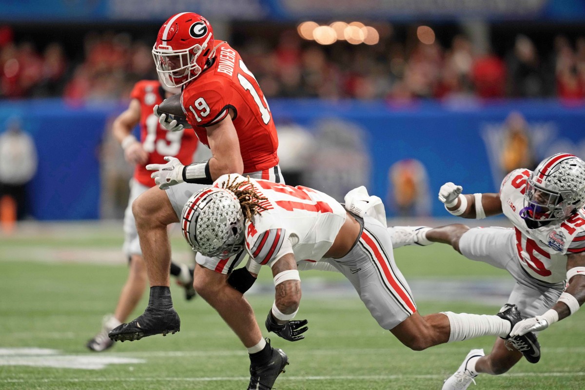 Dec 31, 2022; Atlanta, Georgia, USA; Ohio State Buckeyes safety Ronnie Hickman (14) tackles Georgia Bulldogs tight end Brock Bowers (19) during the first quarter of the 2022 Peach Bowl at Mercedes-Benz Stadium. Mandatory Credit: Dale Zanine-USA TODAY Sports